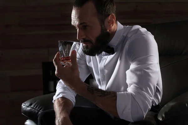 Człowiek Szklankę Whisky Siedząc Fotelu Pomieszczeniu — Zdjęcie stockowe
