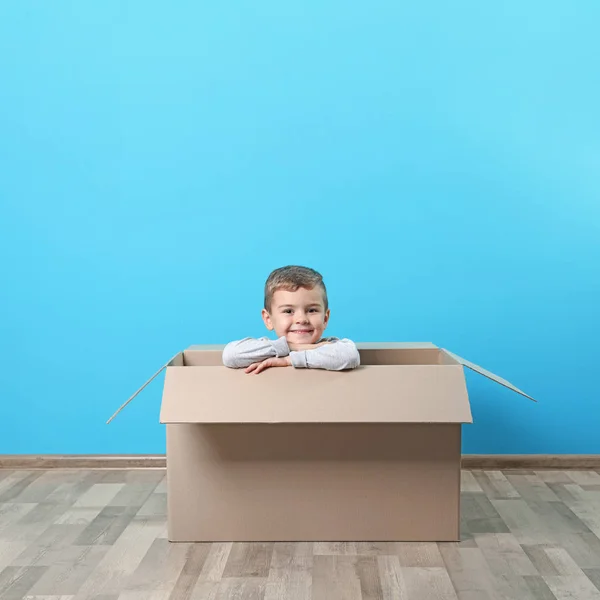 Lindo Niño Jugando Con Caja Cartón Cerca Pared Color — Foto de Stock