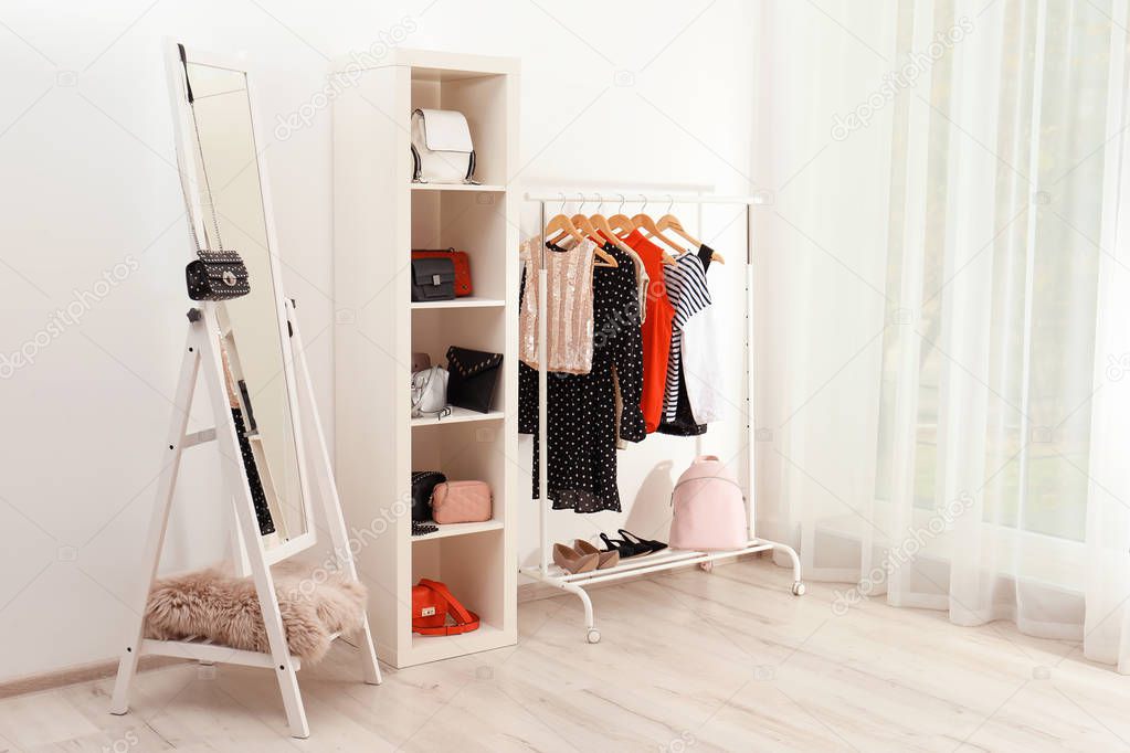 Wardrobe with stylish bags and clothes indoors. Idea for interior design