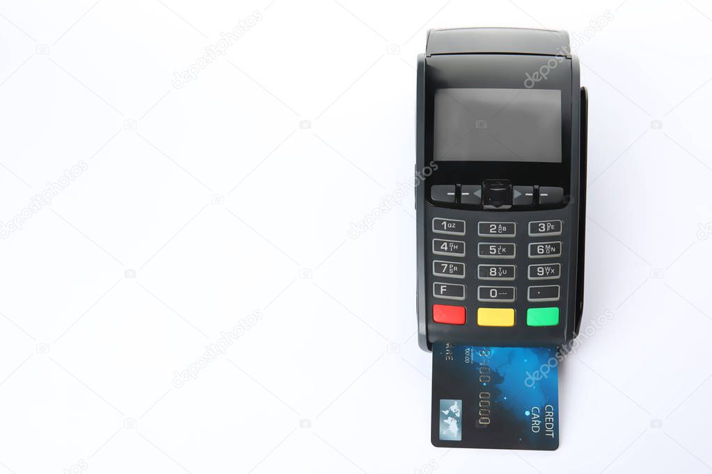 Modern payment terminal with credit card on white background, top view