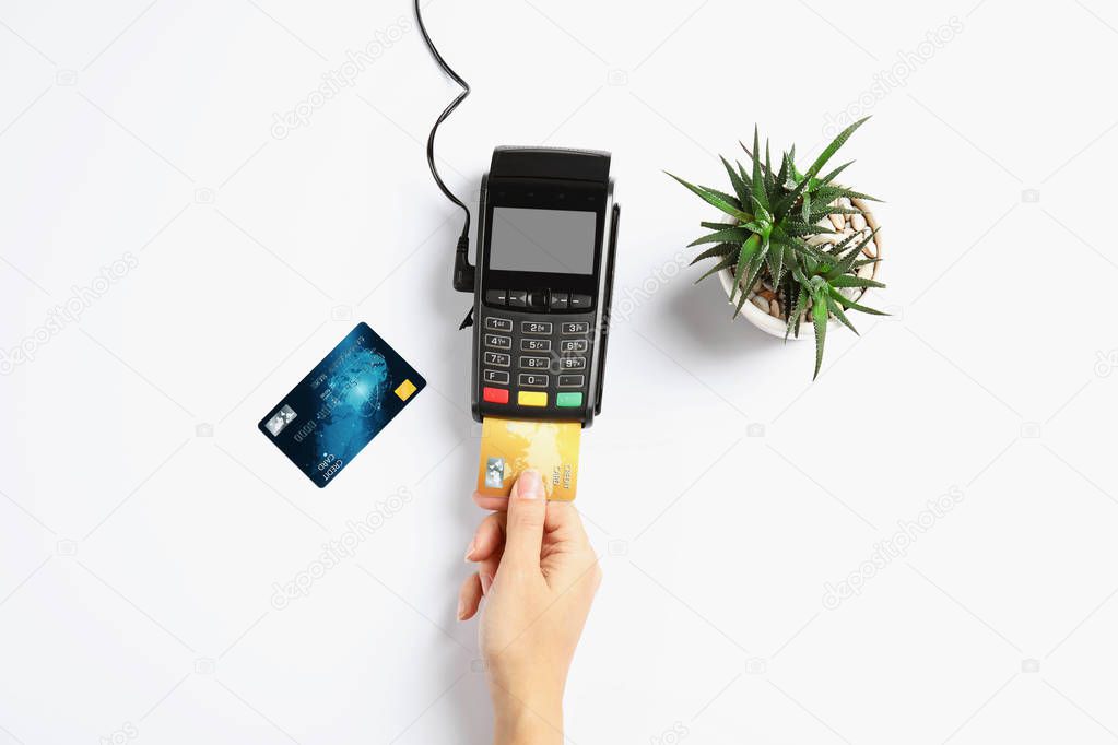 Woman using modern payment terminal on white background, top view