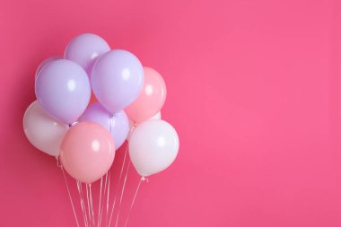Pembe bir arka plan üzerinde renkli parti balonu. Metin için yer