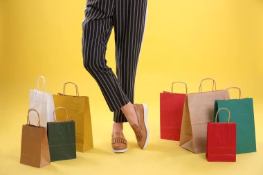 Alışveriş torbaları renk arka plan, closeup bacaklar üzerinde olan kadın