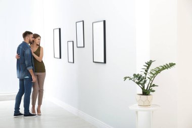 Modern sanat galerisinde sergi ile ilgilenen genç çift