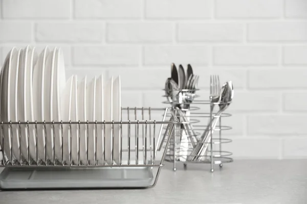 Afdruiprek Met Schone Platen Tafel Buurt Van Bakstenen Muur Ruimte — Stockfoto