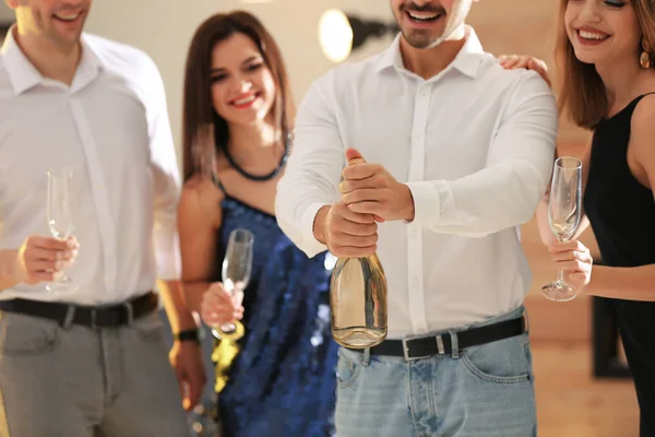 Man Opening Bottle Champagne Friends Party Indoors — Stock Photo, Image