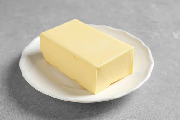 テーブルに新鮮なバターと白プレート — ストック写真