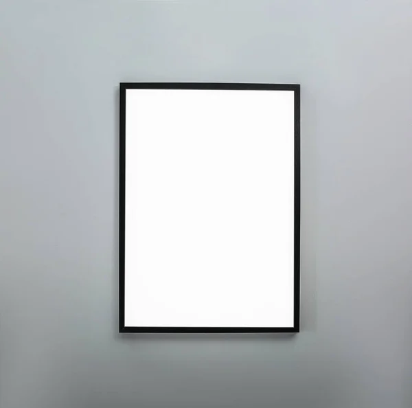 Frame with empty canvas on wall in modern art gallery. Mockup for design