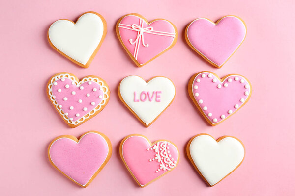 Decorated heart shaped cookies on color background, flat lay. Valentine's day treat