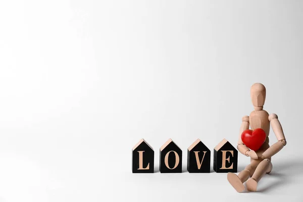 文字爱由装饰字母 木制人体模型和红色的心在白色背景 文本的空间 — 图库照片