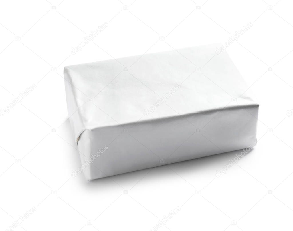 Block of butter in paper wrapper on white background
