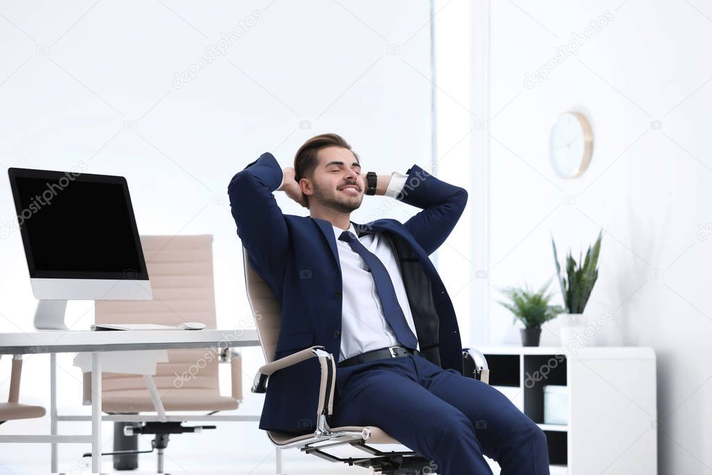 Young businessman sitting on office chair at workplace