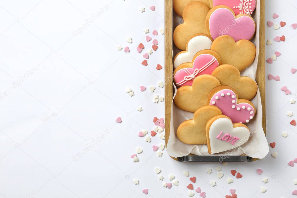 Tray with decorated heart shaped cookies and space for text on white background, top view