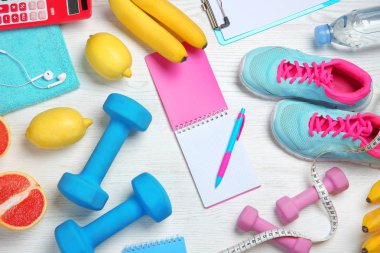 Spor Eşyası, sağlıklı yiyecek ve defter ahşap arka plan üzerinde düz yatıyordu kompozisyonu. Kilo kaybı kavramı