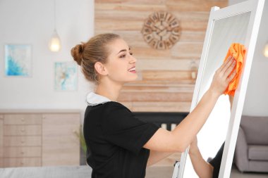 Otel odasında ayna bez ile silerek genç Oda hizmetçisi