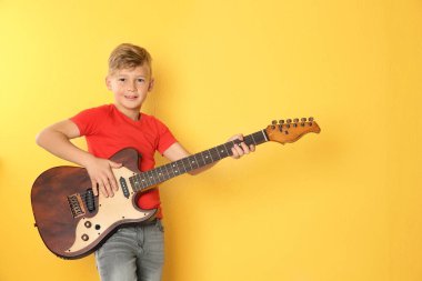 Küçük çocuk renk arka plan üzerinde gitar çalmak. Metin için yer