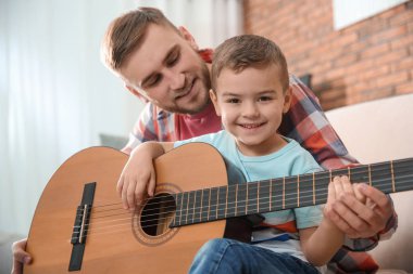 Baba evde gitar çalmayı küçük oğlu öğretim