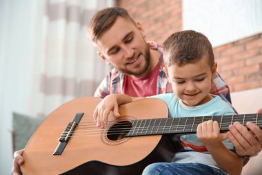 Baba evde gitar çalmayı küçük oğlu öğretim