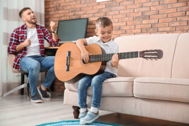 Baba ve oğlu gitar çalmak ve evde şarkı