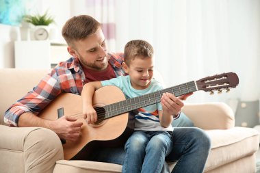 Baba evde gitar çalmayı küçük oğlu öğretim
