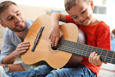 Baba evde gitar çalmayı küçük oğlu öğretim