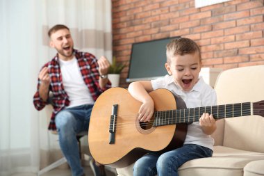 Baba ve oğlu gitar çalmak ve evde şarkı