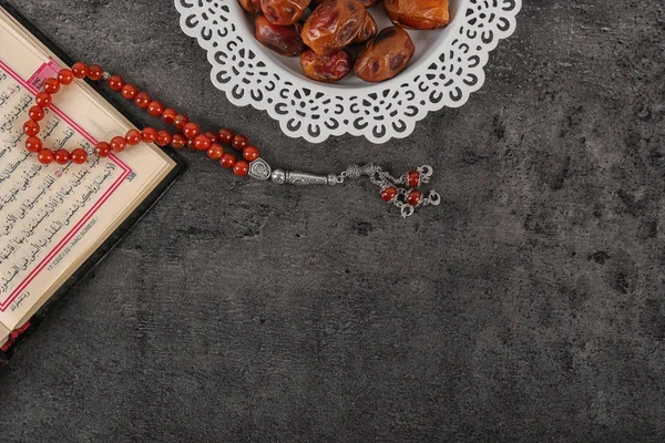 Flat lay composition with Muslim prayer beads, Quran and space for text on grey background