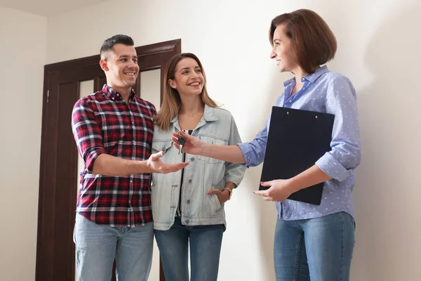 Immobilienmakler Übergibt Wohnungsschlüssel Junges Paar — Stockfoto