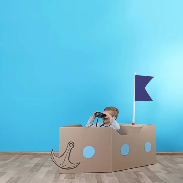 Lindo Niño Jugando Con Barco Cartón Cerca Pared Color Espacio — Foto de Stock