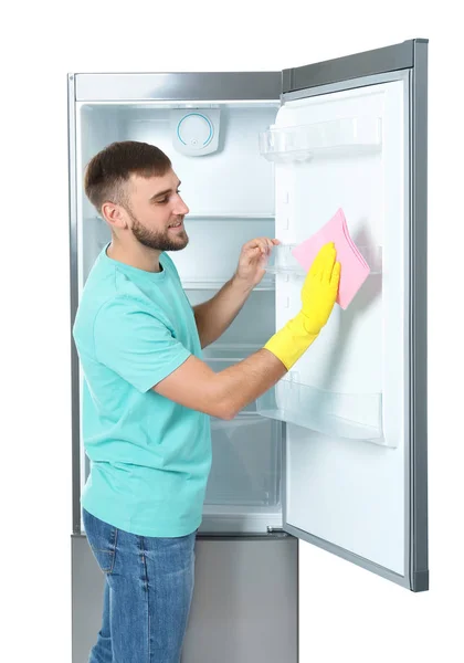 Молодой Человек Чистки Холодильник Тряпкой Белом Фоне — стоковое фото