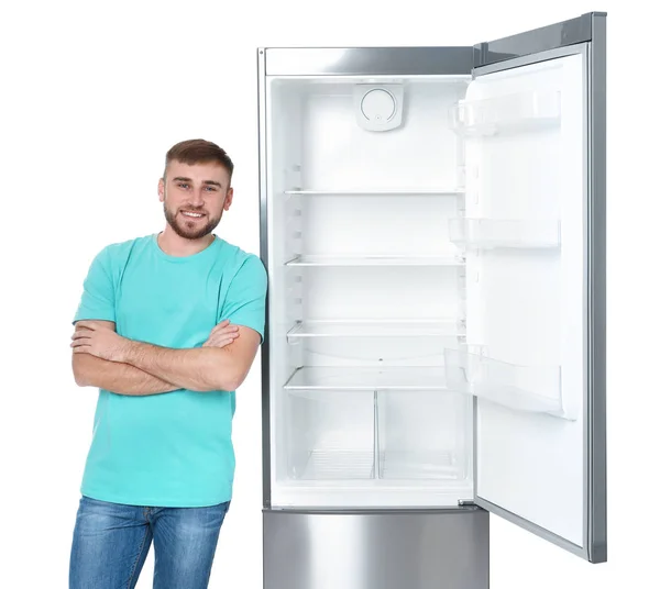 白い背景の空の冷蔵庫近くに若い男 — ストック写真