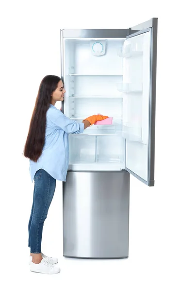Молодая Женщина Моет Холодильник Тряпкой Белом Фоне — стоковое фото
