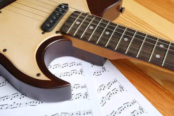 现代电吉他和音乐板料在木背景 — 图库照片