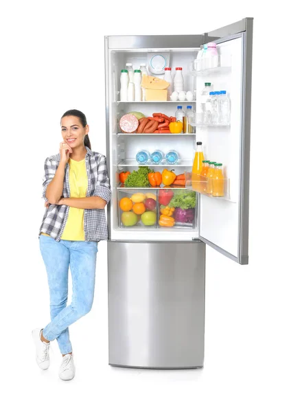白い背景の上のオープン冷蔵庫近くの若い女性 — ストック写真