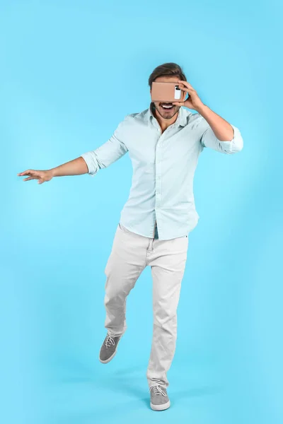Молодой Человек Картонной Гарнитурой Виртуальной Реальности Цветном Фоне — стоковое фото