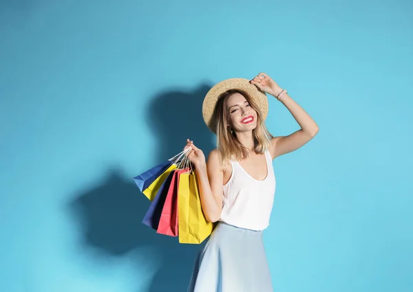 美丽的年轻女子与购物袋在颜色背景 文本的空间 — 图库照片