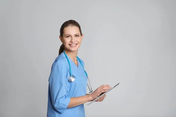 Retrato Jovem Assistente Médico Com Estetoscópio Tablet Sobre Fundo Cor — Fotografia de Stock