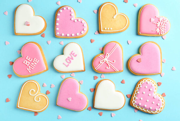Composition with decorated heart shaped cookies on color background, top view. Valentine's day treat