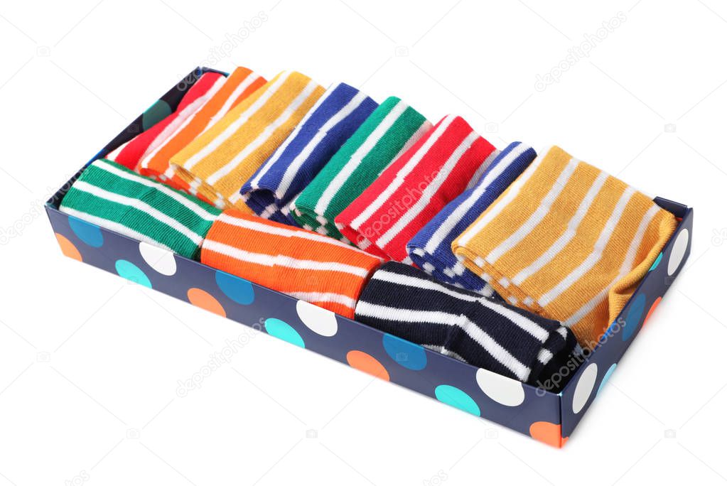 Box with cute child socks on white background