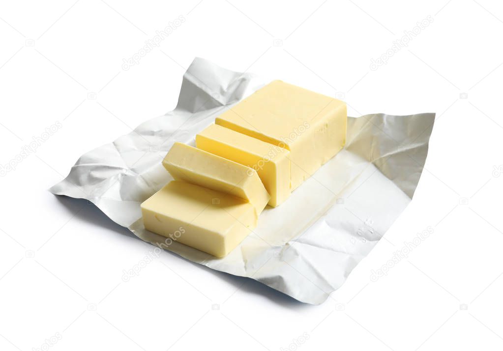 Cut block of fresh butter with wrapper on white background
