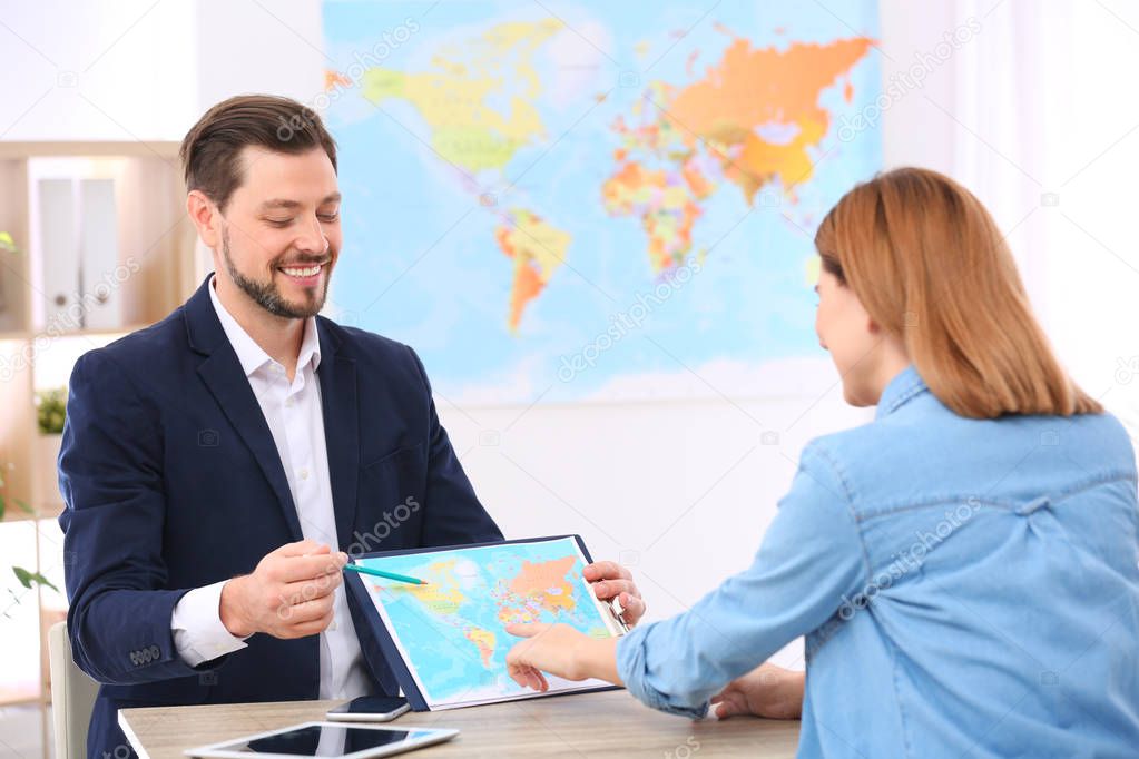 Male manager consulting client in travel agency