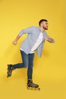 Satır içi tekerlekli paten renk arka plan üzerinde olan genç adam