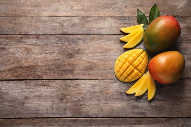 Ahşap arka plan üzerinde mango ile düz yatıyordu kompozisyon. Metin için yer