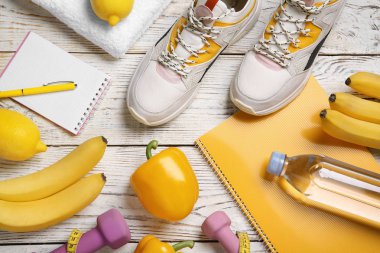 Spor Eşyası, sağlıklı yiyecek ve defter ahşap arka plan üzerinde düz yatıyordu kompozisyonu. Kilo kaybı kavramı