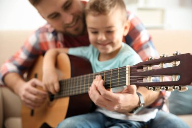 Baba evde gitar çalmayı küçük oğlu öğretim