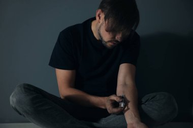 Erkek uyuşturucu bağımlısı gri duvara verme enjeksiyon