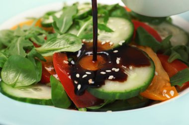 Tabak, closeup taze sebze salatası üzerine dökerek balsamik sirke
