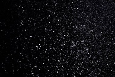 Snow flakes falling on black background. Winter weather clipart