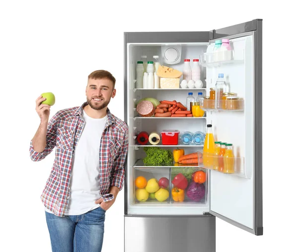 Молодой Человек Яблоком Рядом Открытым Холодильником Белом Фоне — стоковое фото