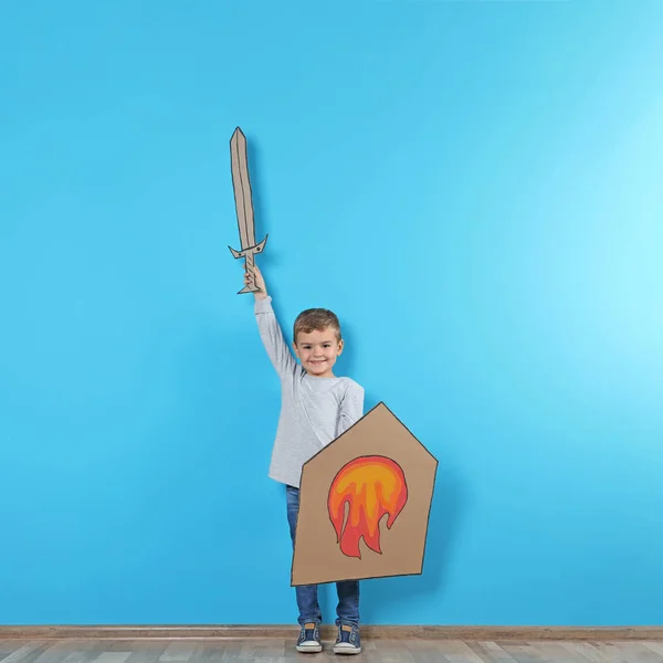 可爱的小男孩玩纸板剑和盾牌附近的彩色墙 文本的空间 — 图库照片